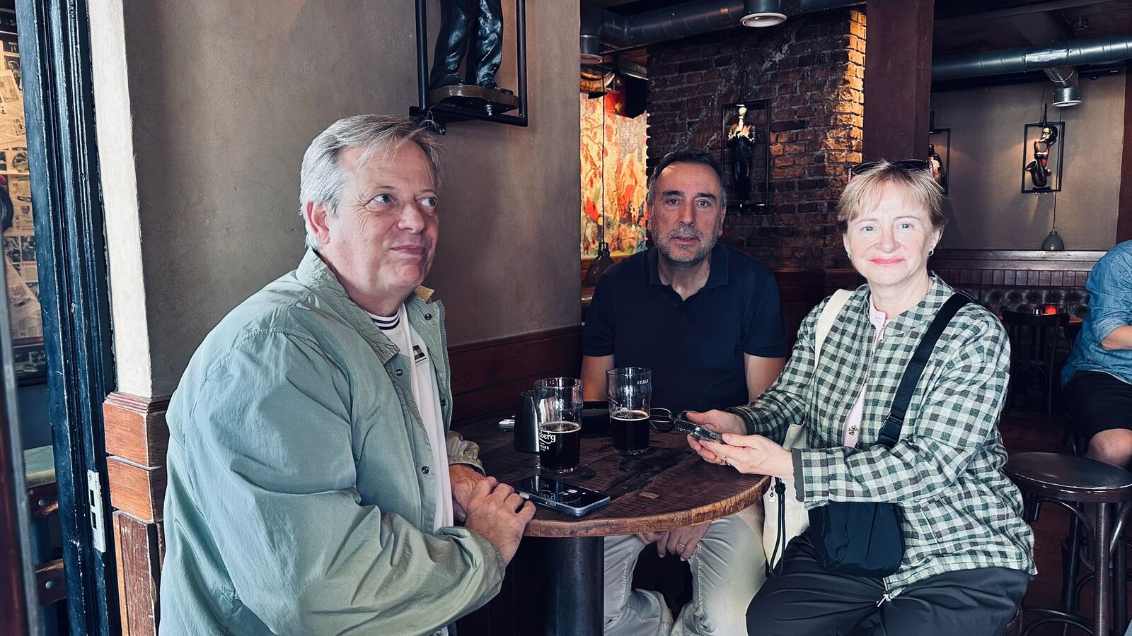 Tres personas tomando una cerveza en un pub de Copenhague