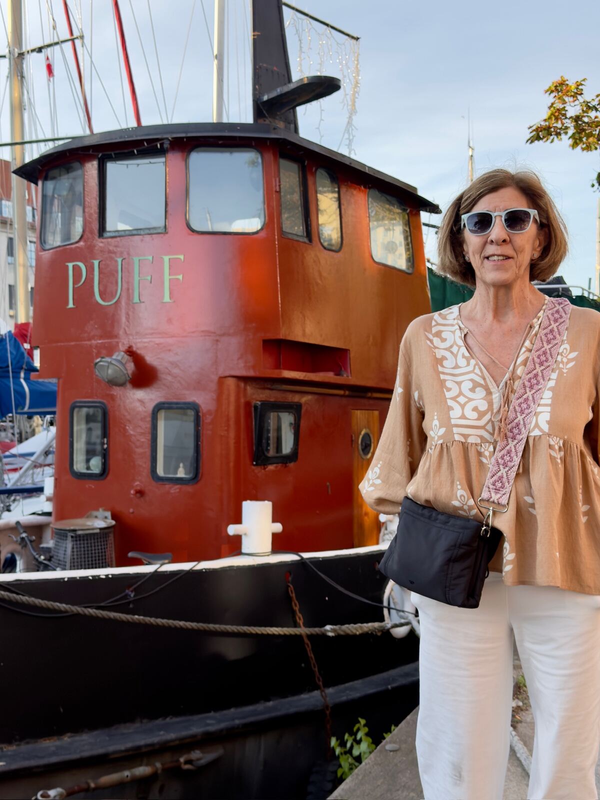 Mujer junto al barco Puff en el puerto