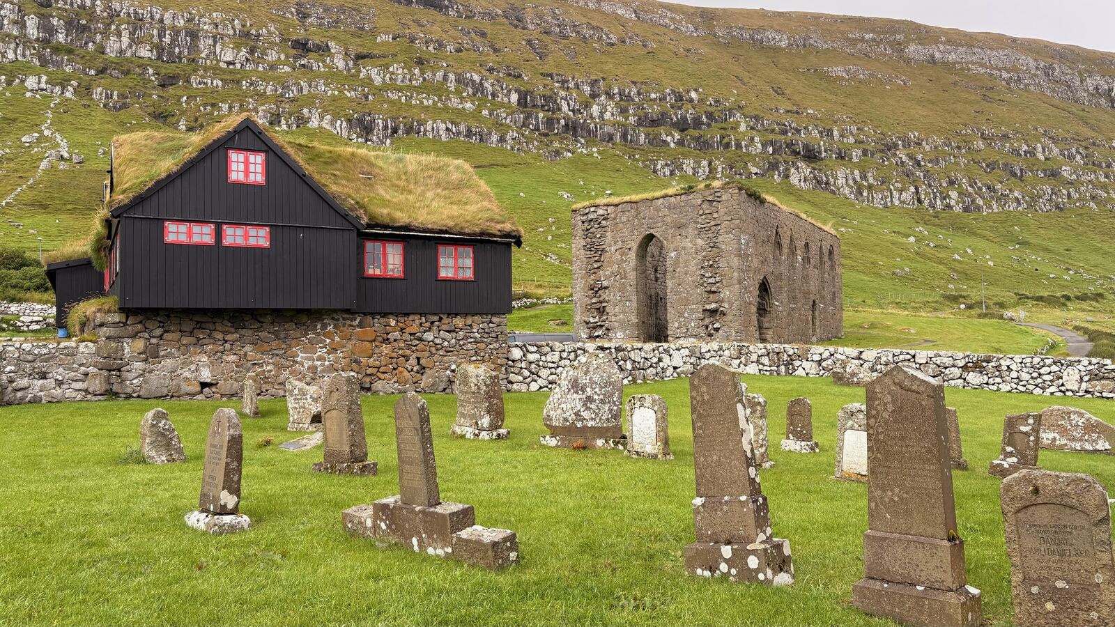 Iglesia negra y ruinas de piedra en Kirkjubøur